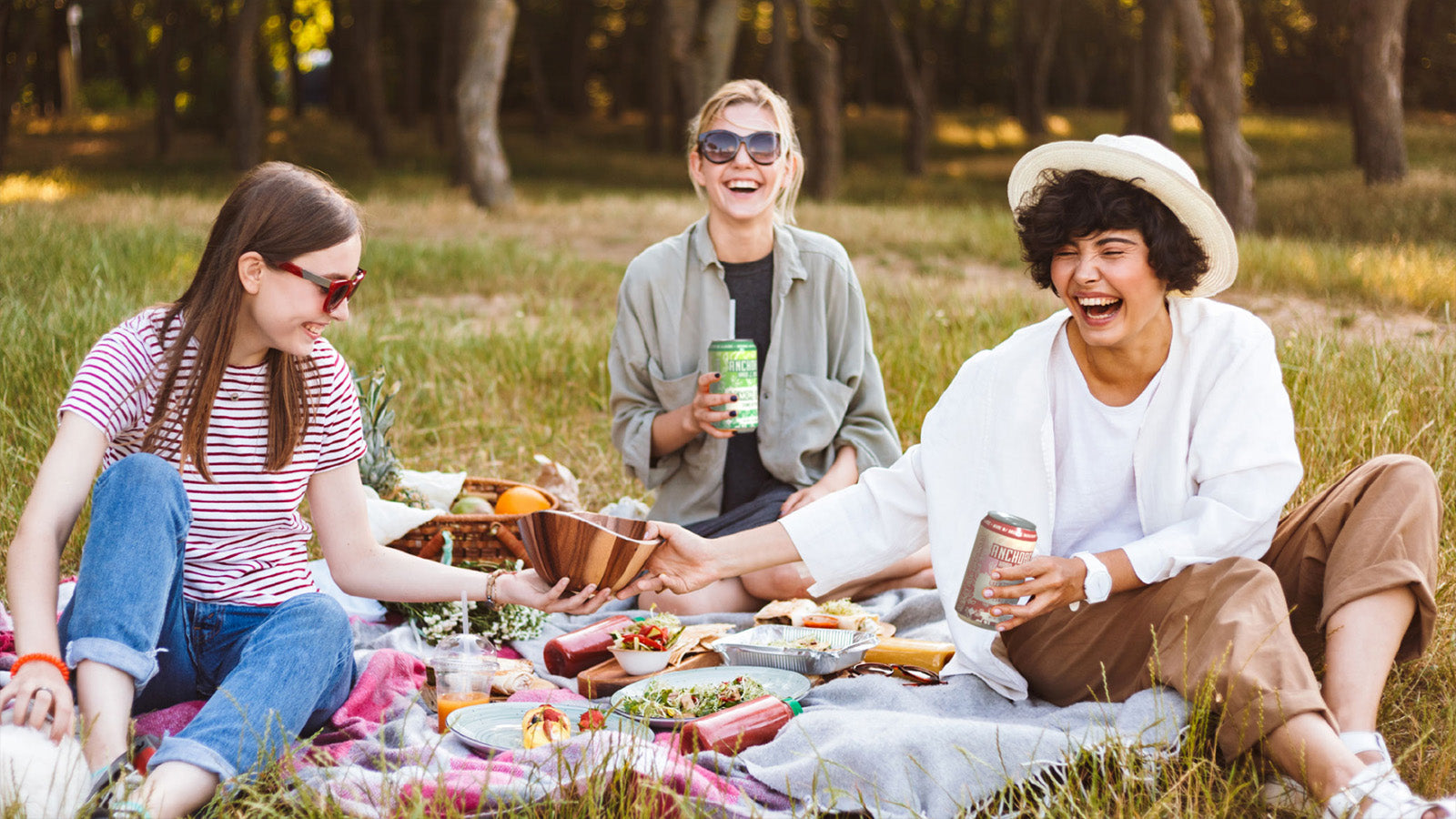 three friends enjoy a charcuterie picnic outside